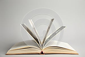 Open old hardcover book on grey background