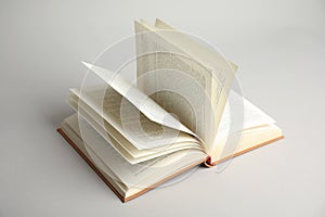 Open old hardcover book on grey background