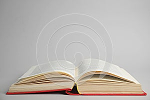 Open old hardcover book on grey background. Space for text
