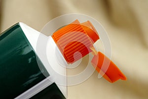 Open orange cap of toothpaste tube