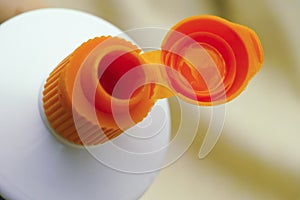 Open orange cap of toothpaste tube
