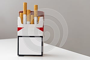 Open pack of cigarettes and a cigarette on a white background.