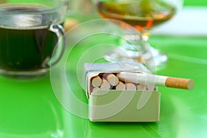 Open pack of cigarettes on a green table