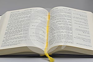Open Page of the Noble Qur\'an Featuring Side-by-Side Arabic Script and English Translation with Yellow Bookmark photo
