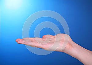 Open palm empty hand on blue background showing ho