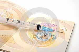 Open passport pages and a vaccination syringe