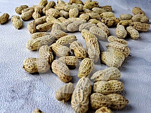Open peanuts shot macro in studio, white wall texture background