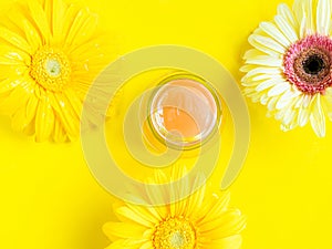 Open pink gel cream peeling jar on yellow background