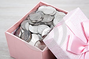 Open pink gift box with russian ruble coins