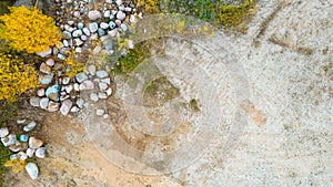 Open pit gravel mining sight with gravel field, big stones and beautiful autumn nature photographed from above with a drone.