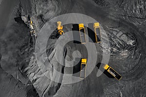 Open pit mine, coal loading in trucks, transportation and logistics, top view aerial. Concept industrial