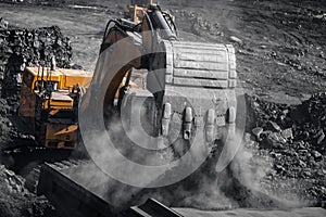 Open pit mine industry. Excavator work loading of coal into Yellow mining truck