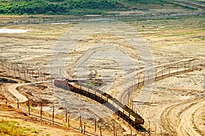 The open-pit mine, mining train carrying excavated materials at the forefront