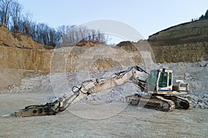 Open pit mining site of construction sand stone materials with excavator equipment for digging of gravel resources at