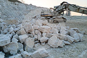 Open pit mining site of construction sand stone materials with excavator equipment for digging of gravel resources at