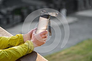 Open plastic fitness water bottle with a cap in a female hands