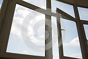 Open plastic window at the background of blue sky