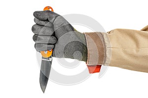 Open pocket folding knife with bright orange handle clenched in a man fist in black protective glove isolated on white background