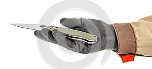 Open pocket folding knife with dark green handle lies in palm of worker hand in black protective glove and brown uniform isolated