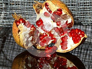 Open pomegranate with red beads on wire netting