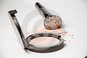 Open powder box, black make-up brush, powder hill