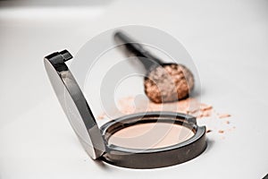 Open powder box, black make-up brush, powder hill