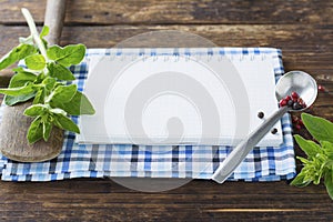 Open recipe book with vegetables and herbs on a wooden background.