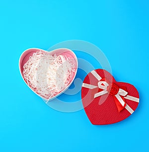 open red heart-shaped gift box with a bow on a blue background