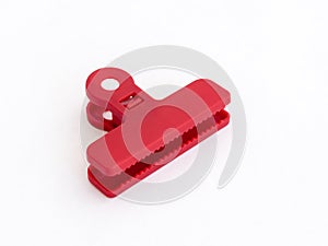 Open red plastic medium size clothespin for plastic bags isolated on a white background