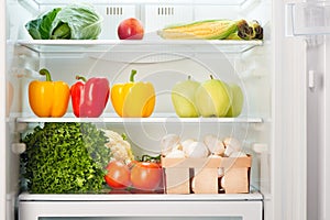 Open refrigerator full of fruits and vegetables