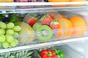 Open refrigerator full of healthy food, closeup. Fruits and vegetables