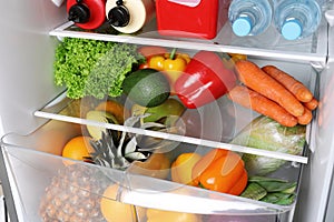 Open refrigerator with many different products