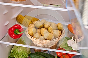 open refrigerator with organic potatoes basket