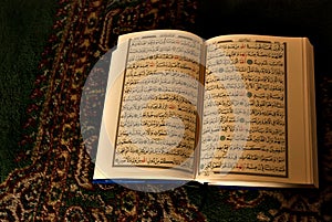 Open religious textbook in arabic writting on oriental carpet