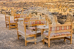 An open restaurant with wood tables and chairs with background of Goreme town,Cappadocia ,Turkey