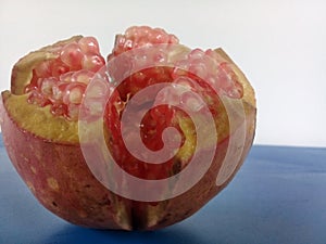 Open ripe pomegranate fruit on blue tabel