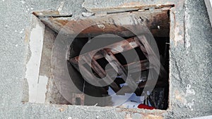 Open road hatch with water and pallet inside. Road under construction with open hatch. Road closed ahead.