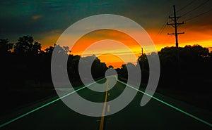 An open road & x28;state route 322& x29; at dusk while facing a sunset in Orwell, Ohio