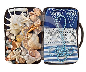 Open road suitcase with clothes and shells