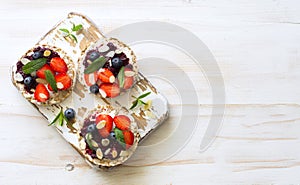 Open sandwiches with cream cheese, strawberries, blueberries, jam and almond flakes