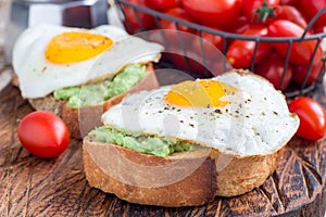 Open sandwiches with mashed avocado and fried egg, horizontal