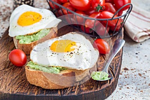 Open sandwiches with mashed avocado and fried egg, horizontal, copy space