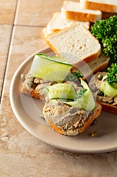 Open sandwiches with pate, cucumber, capers, and parsley