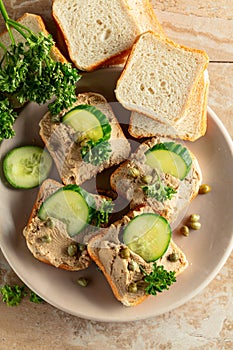 Open sandwiches with pate, cucumber, capers, and parsley