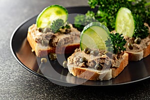 Open sandwiches with pate, fresh cucumber, capers, and parsley