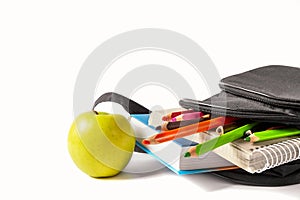 Open school backpack on an white background. Books, a notebook and pencils are sticking out of an open school backpack