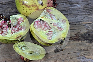 Open section of a pomegranate fruit exposing the ripe red seeds within.