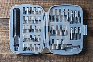 Open set of the interchangeable flat and hexagonal bits different sizes for screwdriver in gray plastic box