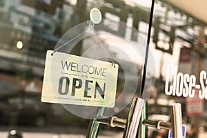 Open sign broad through the glass of window at coffee shop.