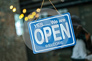 Open  sign broad through the glass of window at coffee shop